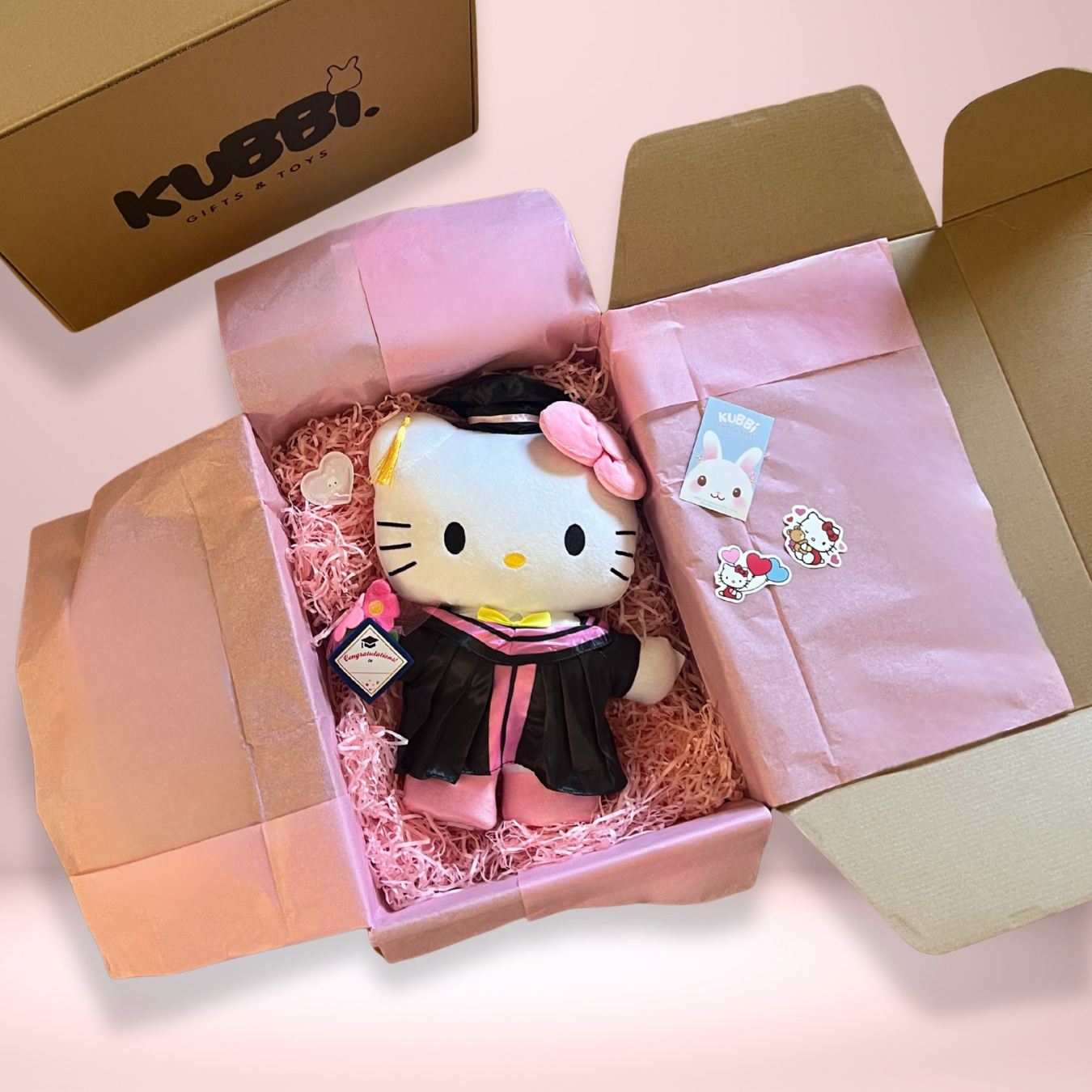 Hello Kitty plush graduation gift wrapped in pink tissue paper in a decorative box and KUBI branding